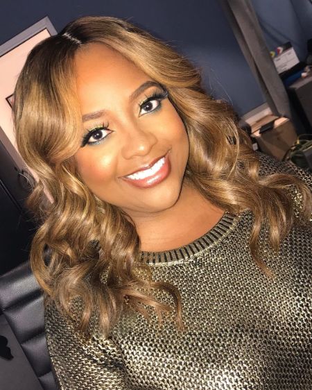 Actress Sherri Shepherd in a brown dress poses for a picture.